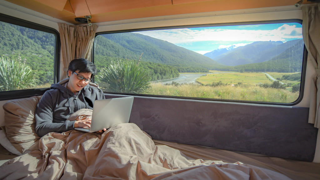 a man insife a motorhome while working in bed