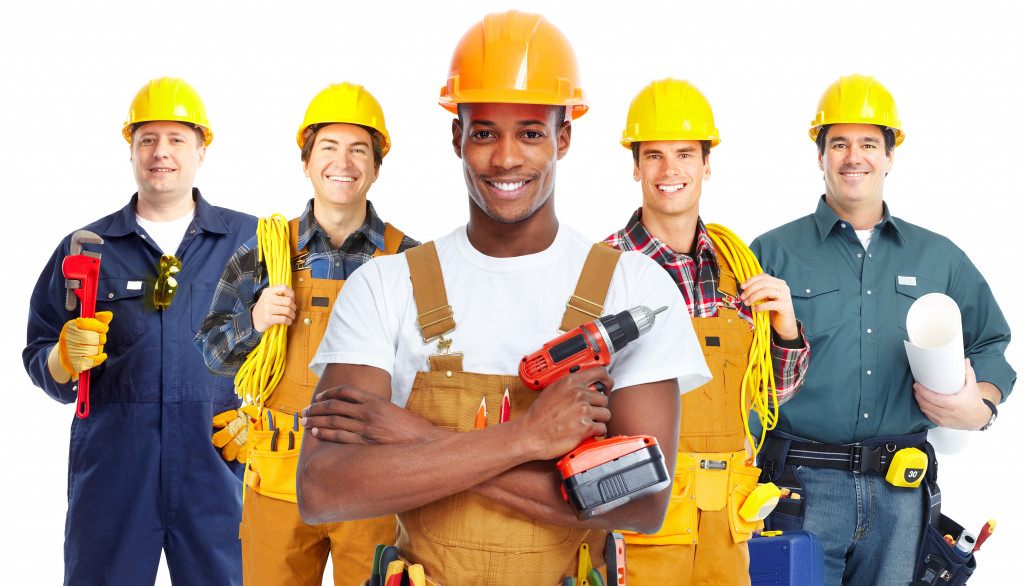 group of contractors holding tools in a white background