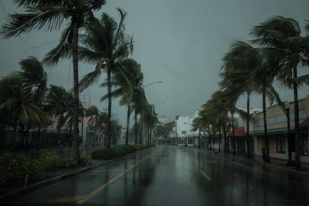 A dark, empty street with closed shops during a hurricane