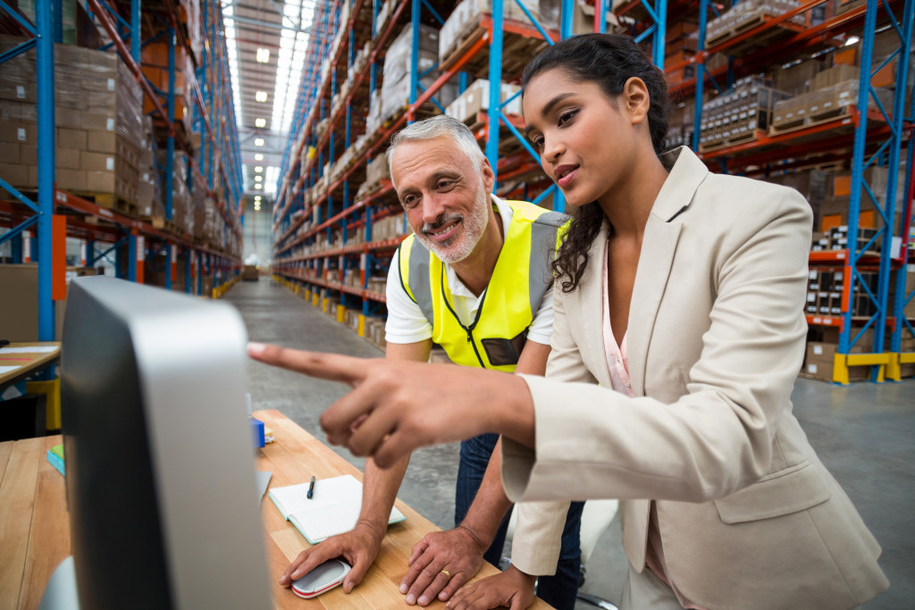 A woman in a warehouse teaching a staff