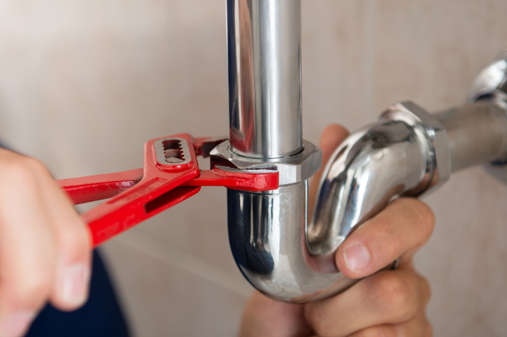 plumber fixing pipe with wrench