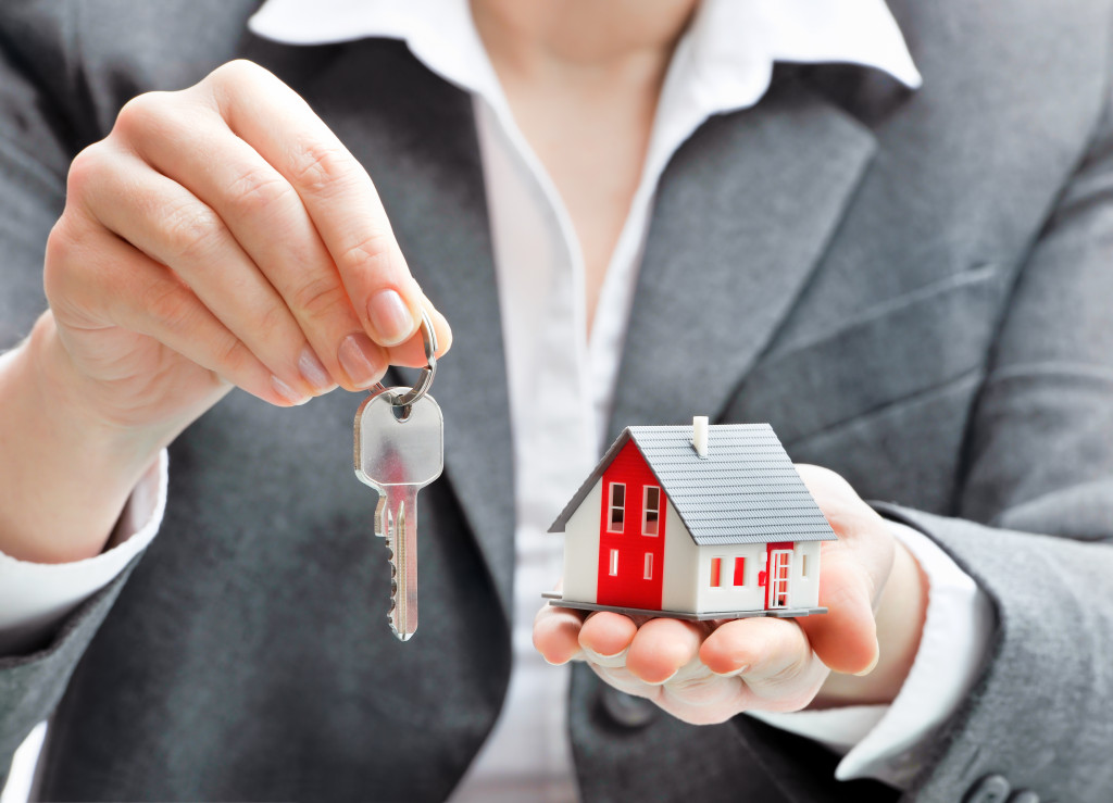 real estate agent holding key and house model