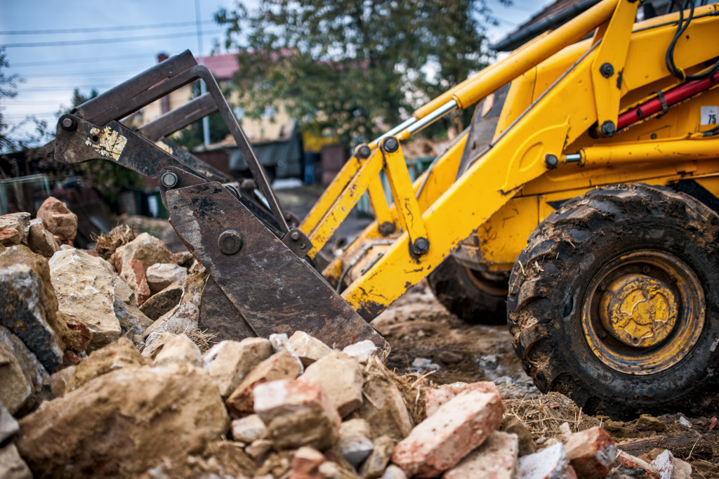 A yellow bulldozer clearing debris on a construction site