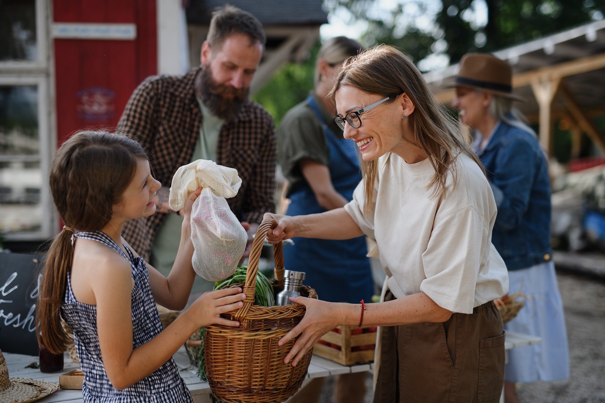 mother and daughter buying organic vegetables at farmer's market