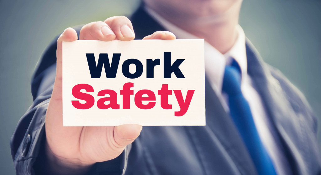 businessman holding cardboard with work safety printed on it