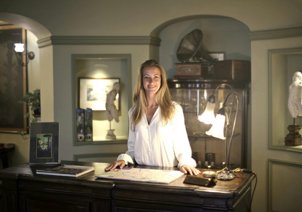 hotel owner standing behind the reception desk